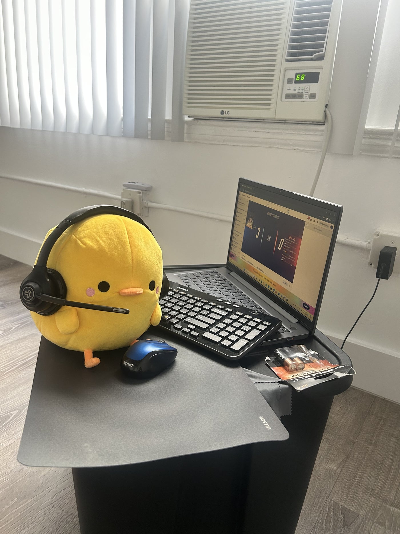 Yellow Henry plush beside a laptop on a desk